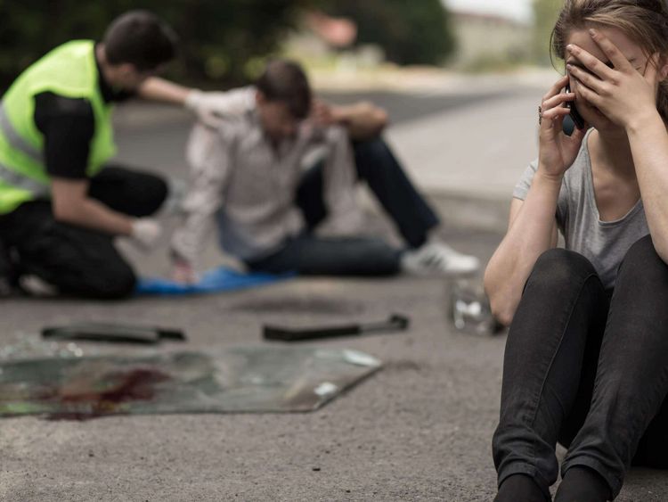 Helfer spricht mit Opfer nach Verkehrsunfall