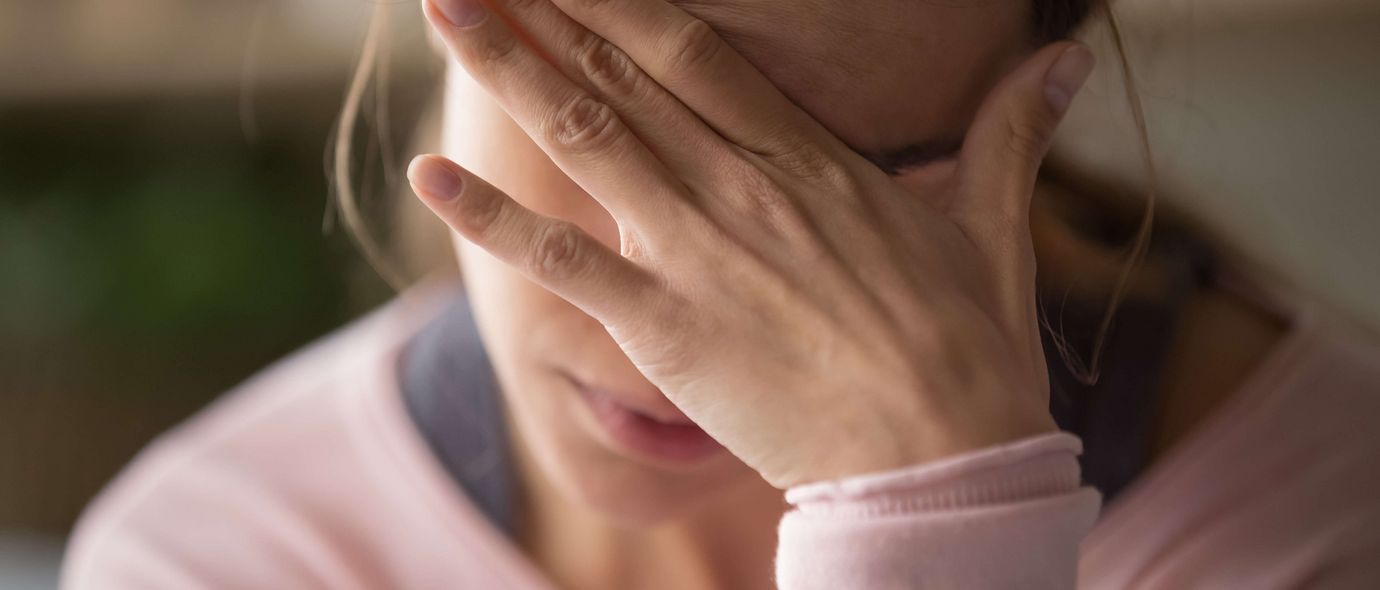 Erschöpfte Frau hält die Hand an die Stirn